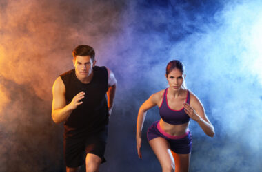 Sporty running young couple on dark background